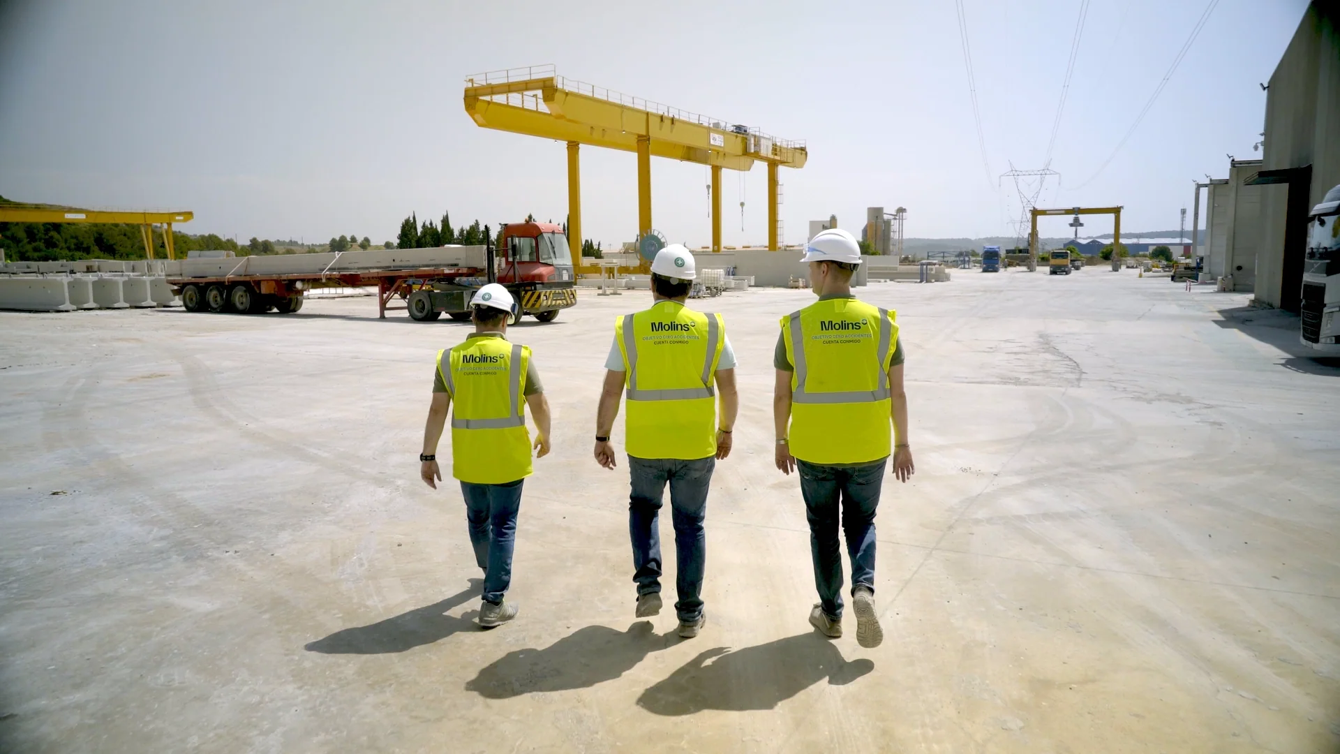 Tres trabajadores de Molins caminando por una planta industrial